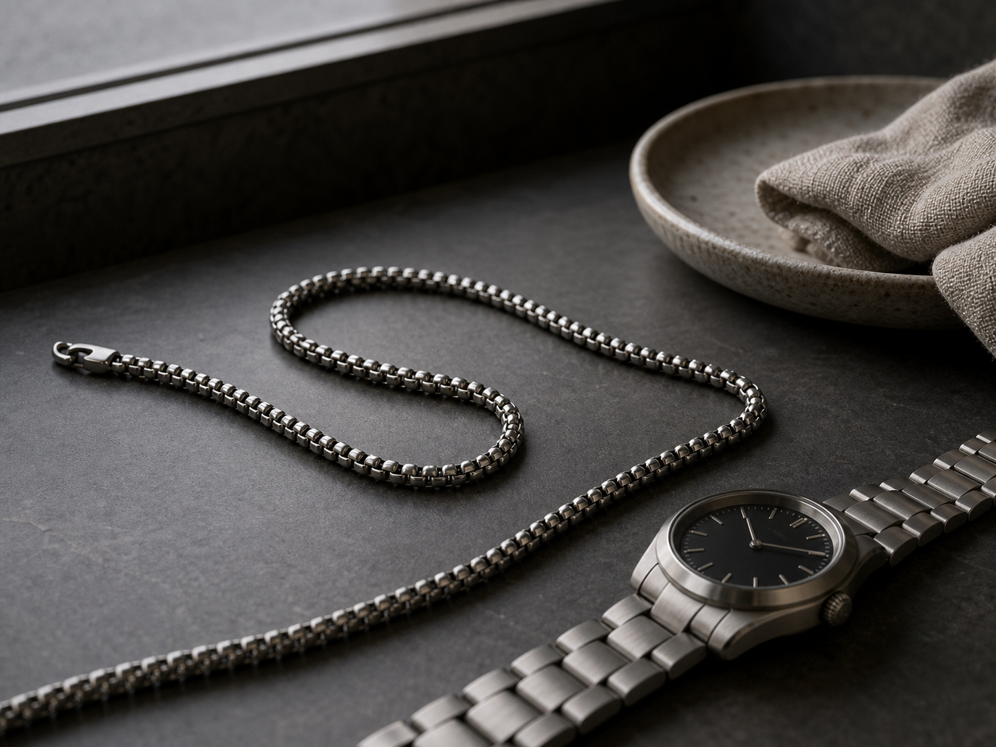 Matte titanium chain and watch bracelet details in quiet luxury styling